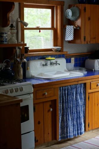 a kitchen with a sink and a window at Maggie's Place on the Cabot Trail in Birch Plain