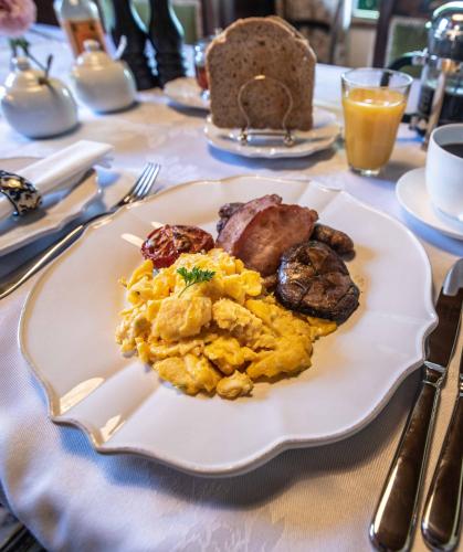 a plate of scrambled eggs and sausage on a table at French Bay House in Akaroa