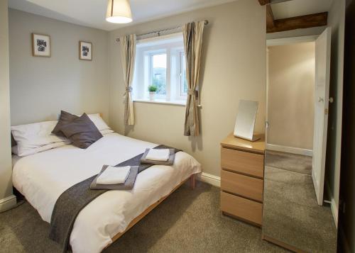 a bedroom with a bed and a window at Host & Stay - Cosy Cottage in Emley