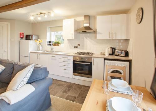 a kitchen and living room with a couch and a table at Host & Stay - Cosy Cottage in Emley