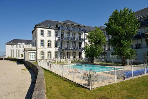 un immeuble avec une piscine devant un immeuble dans l'établissement Residence Saint Goustan - maeva Home, au Croisic