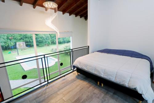 ロルダンにあるHermosa Casa con Pileta Roldán Funes Rosarioのベッドルーム(ベッド1台付)、バルコニーが備わります。