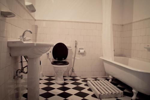a bathroom with a toilet and a sink and a tub at Ancoombra Tea Estate Bungalow in Matale
