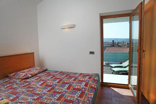 a bedroom with a bed and a door to a balcony at Spacious Villa in Parecag with a Swimming Pool in Sečovlje