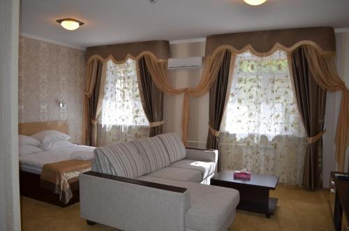 a living room with a couch and a bed at Mereke Hotel in Ustʼ-Kamenogorsk