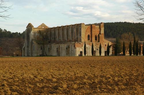 an old building with a field in front of it at Collepetrucci in Ciciano