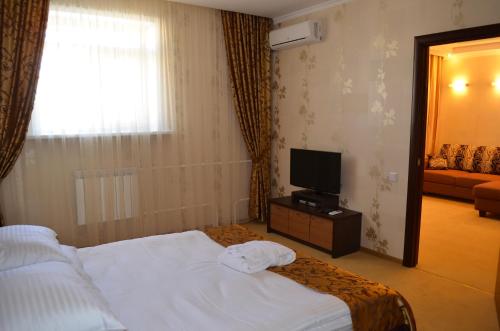 a hotel room with a bed and a television at Mereke Hotel in Ustʼ-Kamenogorsk