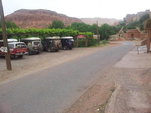 a row of trucks parked on the side of a road at Hotel Awayou in Bou Tharar