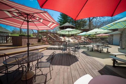 a group of tables and chairs with umbrellas on a deck at The Stone Castle Hotel & Conference Center in Branson