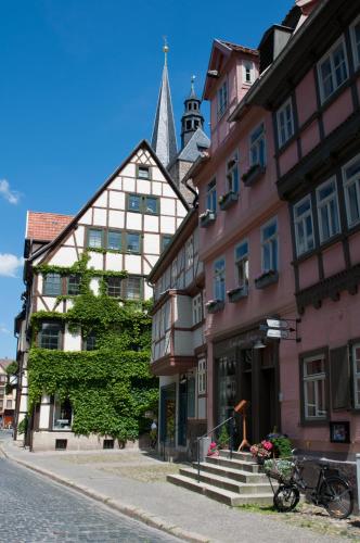 a street in a town with buildings and a church at Hotel am Hoken in Quedlinburg