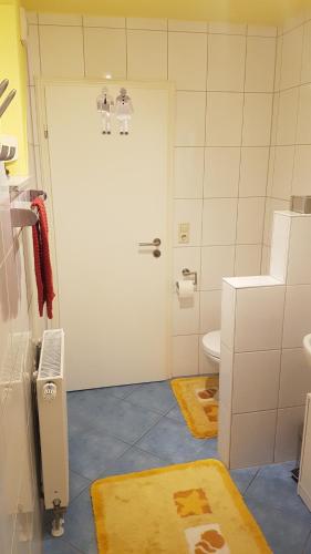 a bathroom with a white door and a toilet at Ferienwohnung "Waldeck" Nahe Messe und Bodensee in Friedrichshafen