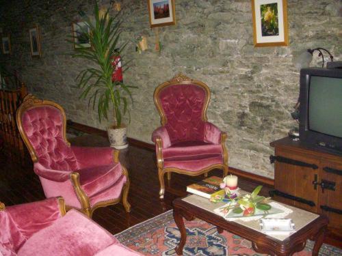 a living room with two chairs and a tv at Quinta Da Azenha in Folgosa