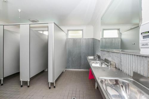 a bathroom with two sinks and two mirrors at Port Macquarie Backpackers in Port Macquarie