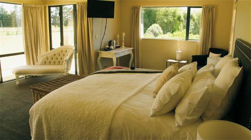 a bedroom with a large white bed with a window at Tuscany Downs Estate in Darfield