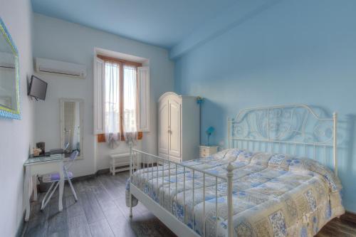 a blue bedroom with a bed and a desk at Il Viaggiator Leggero in Florence