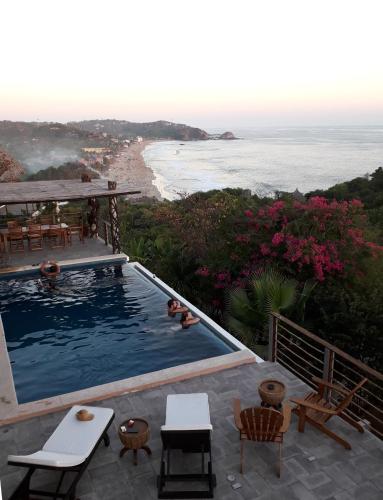 a swimming pool with a view of the ocean at Casa Kalmar in Zipolite