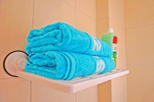 a pile of towels sitting on a shelf in a bathroom at Villages road Suite in Hurghada