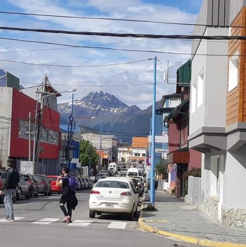 una mujer cruzando una calle en una ciudad con una montaña en Ushuaia Centro en Ushuaia