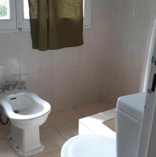 a white bathroom with a toilet and a sink at Ushuaia Centro in Ushuaia