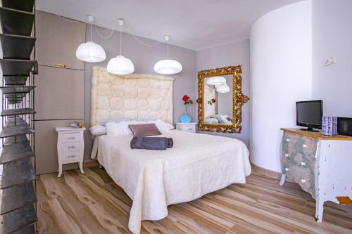 sypialnia z białym łóżkiem i lustrem w obiekcie Apartamento Loft pleno centro, vistas fantasticas w mieście Torremolinos