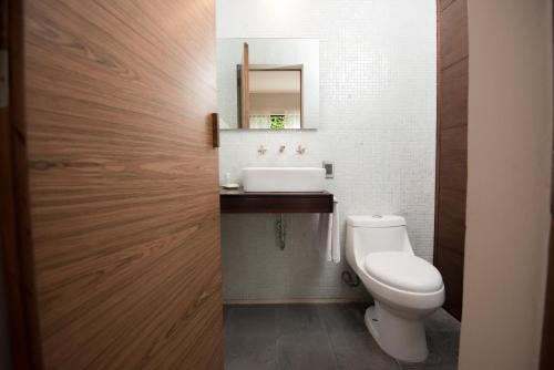 a bathroom with a white toilet and a sink at Nardazul "Casa de Sueños" in Oaxaca City
