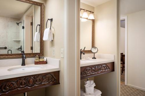 a bathroom with a sink, toilet and mirror at Victorian Inn in Monterey