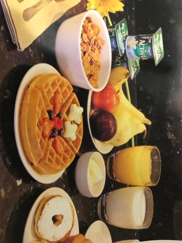 una mesa cubierta con gofres y otros productos para el desayuno en Trip Hotel Ithaca, en Ithaca
