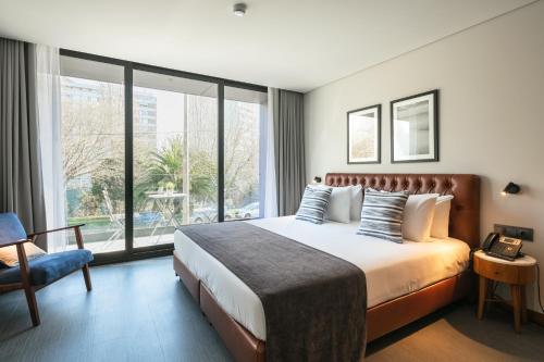 a hotel room with a bed and a large window at Porto City House in Porto