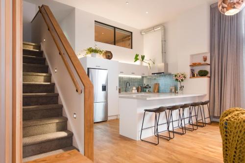eine Küche und ein Wohnzimmer mit Treppe und Theke in der Unterkunft Anzac North Loft - 4 Bedrooms & 2 Free Car Parks in Auckland
