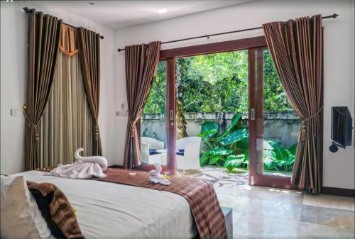 a bedroom with a bed and a large window at Villa Collard in Senggigi 