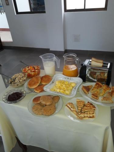 a table with plates of pastries and other food on it at El Jardin De Su Merced B&B in Sucre