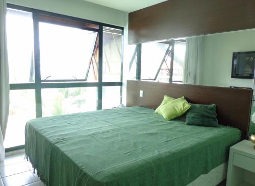1 dormitorio con cama verde y ventana grande en Marulhos resort en Porto De Galinhas