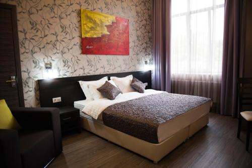 a bedroom with a bed and a painting on the wall at Boutique Apart - Hotel iArcadia in Odesa