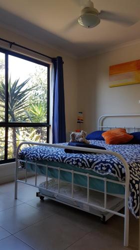 a bedroom with a bed and a large window at Pebbles Beach Retreat in Cowes