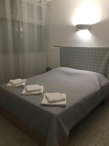 a bedroom with a bed with two towels on it at le méridien les pieds dans l'eau in Sainte-Anne