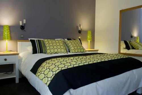 a bedroom with a large bed with green pillows at The Vernon in Droitwich