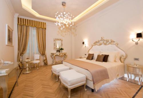 a bedroom with a large bed and a chandelier at Grand Hotel Da Vinci in Cesenatico