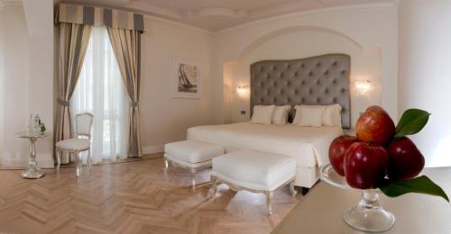 a bedroom with a bed and a table with a vase of fruit at Grand Hotel Da Vinci in Cesenatico