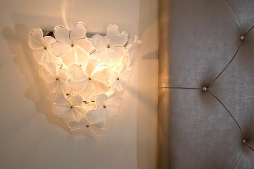 a chandelier with white flowers on a wall at Grand Hotel Da Vinci in Cesenatico