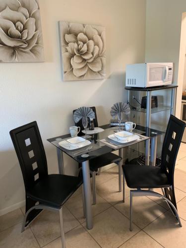 a dining room with a table and chairs and a microwave at Sienna Park Apartments in Sarasota