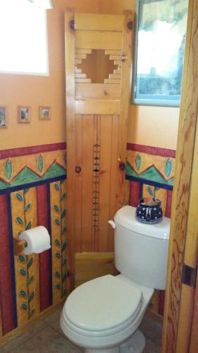 a bathroom with a white toilet and a window at Kokopelli's Hideaway in Julian