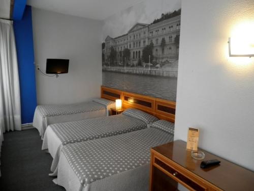 uma fila de camas num quarto com uma fotografia na parede em Hotel Photo Zabalburu em Bilbau