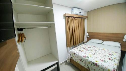 a small bedroom with a bed and a closet at Hotel Morada do Mar in Guarujá