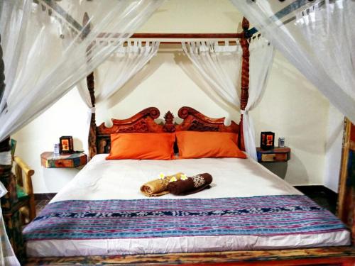 a bedroom with a bed with orange pillows at Lunar Dive Resort in Tulamben