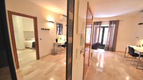 a hallway with a room with a bed and a mirror at Apartamentos Living Sevilla Centro Maestranza in Seville