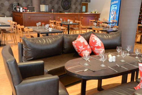 a restaurant with a leather couch and tables and chairs at CATANGE HOTEL in Charata