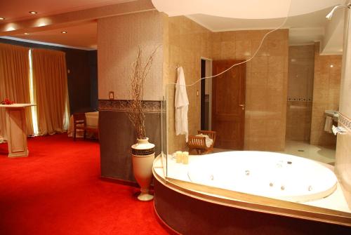 a large bathroom with a large tub and red carpet at CATANGE HOTEL in Charata