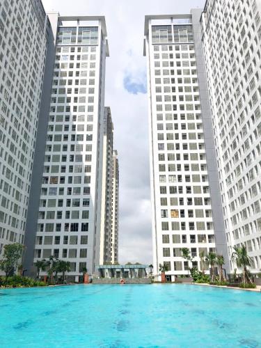 a pool in front of three tall buildings at M-Town Residences by Taslim Gading Serpong in Tangerang