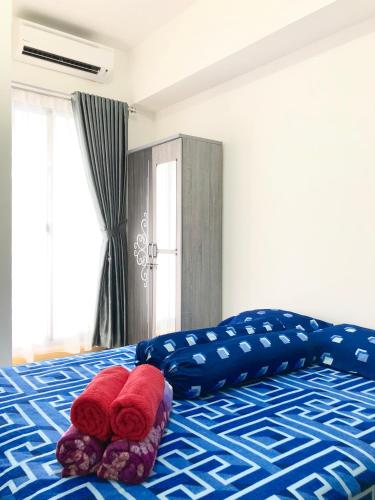 a bedroom with a bed with two pillows on it at M-Town Residence Gading Serpong by Taslim Property in Tangerang