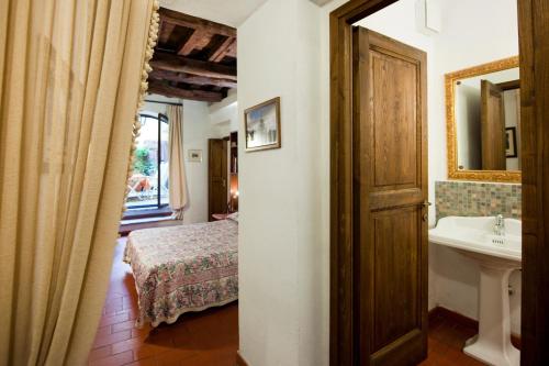 a bathroom with a sink and a bed and a mirror at Palazzo Maggiore in Tivoli